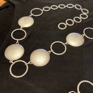 Silver chain belt with open and closed silver metals, 45 inches long.